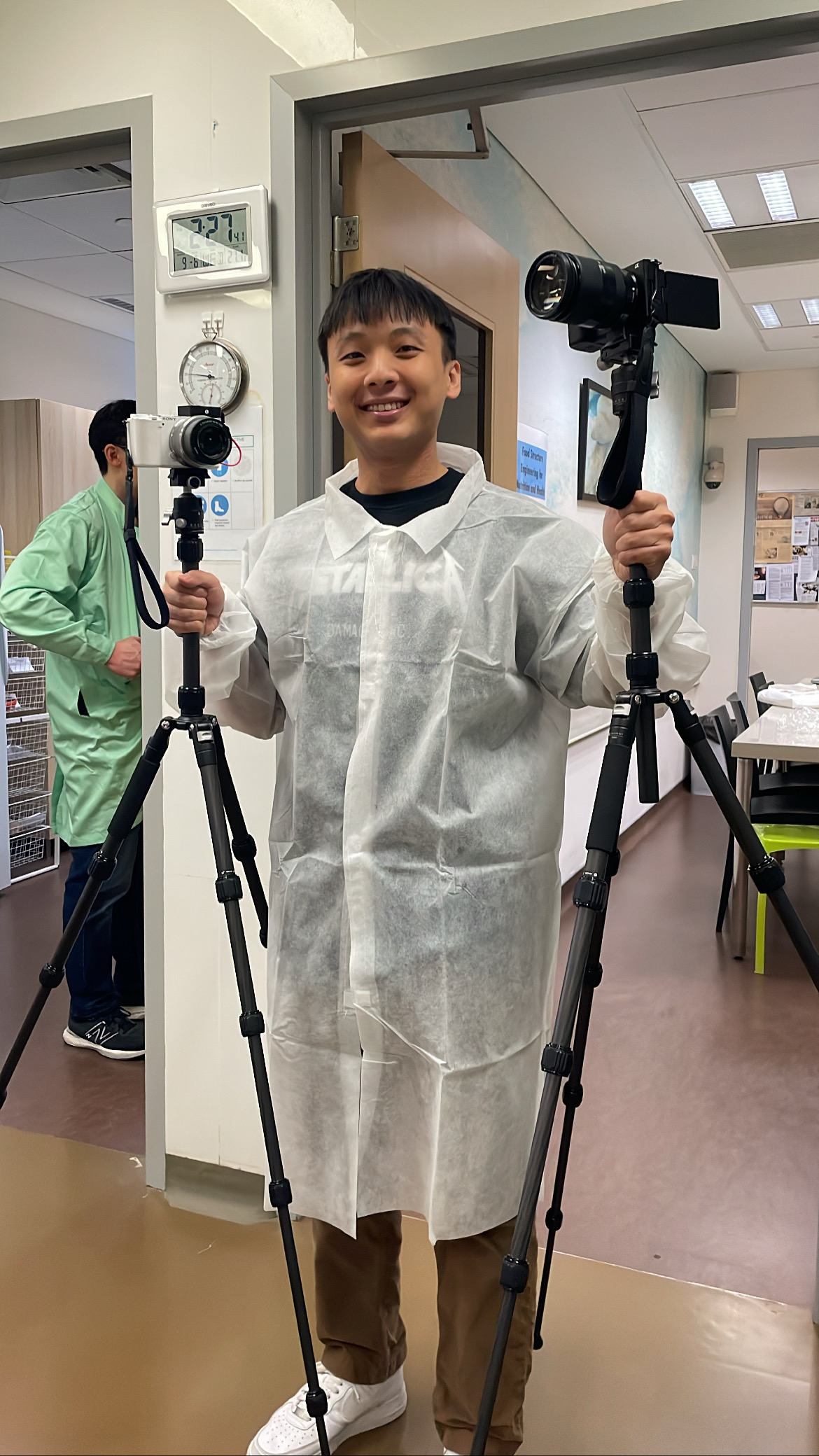 Jarrod Chua holding up camera tripods