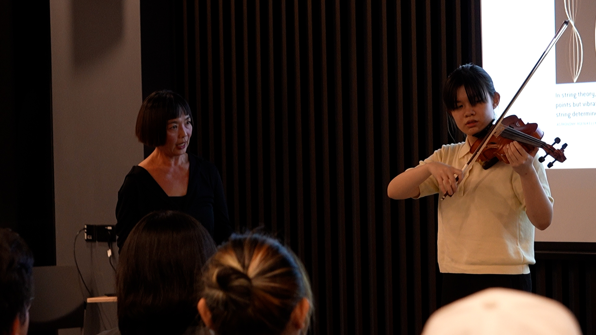 Dr. Joyce Koh and an attendee demonstrating harmonics through an impromptu violin performance.