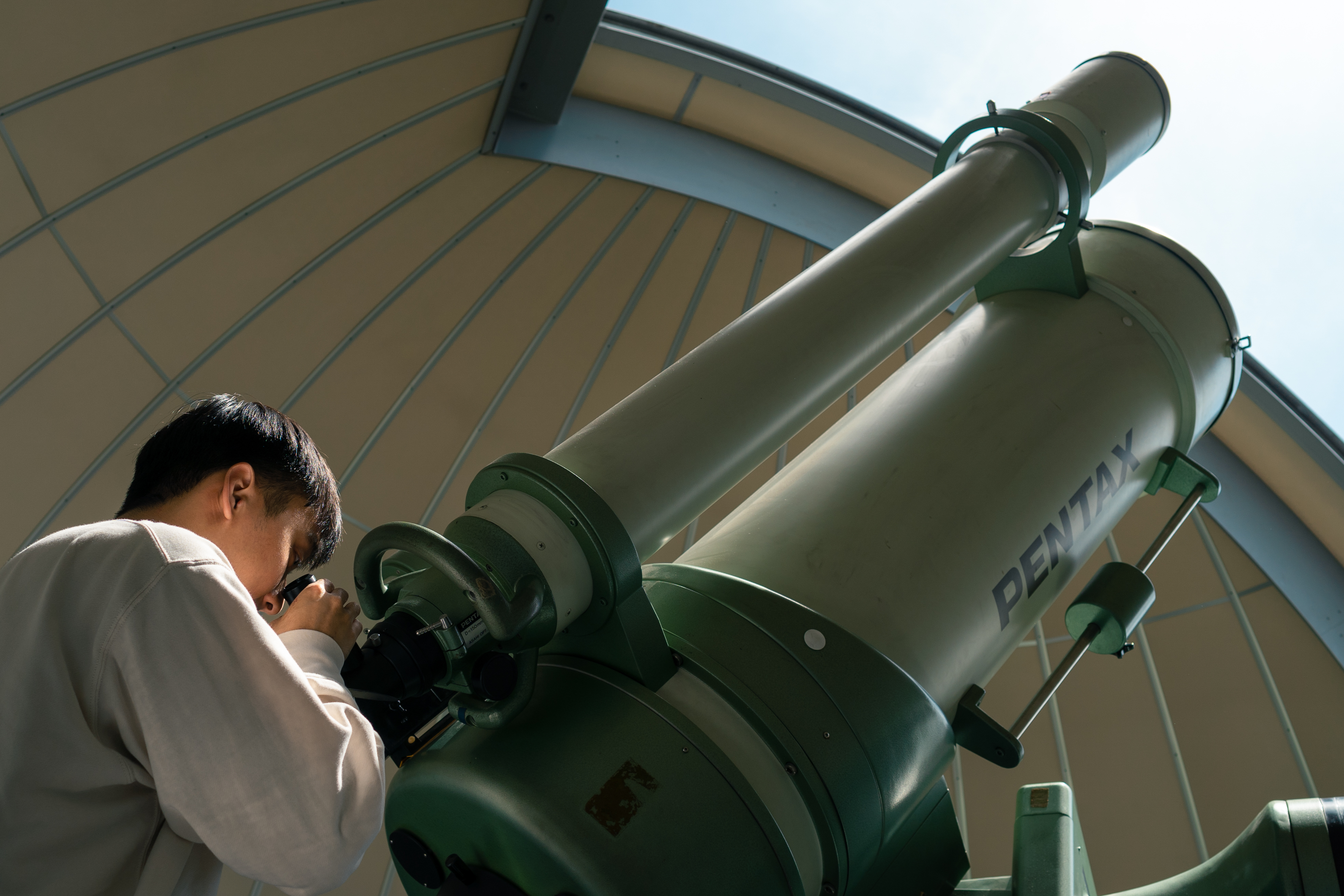 Jarrod Chua peering through telescope