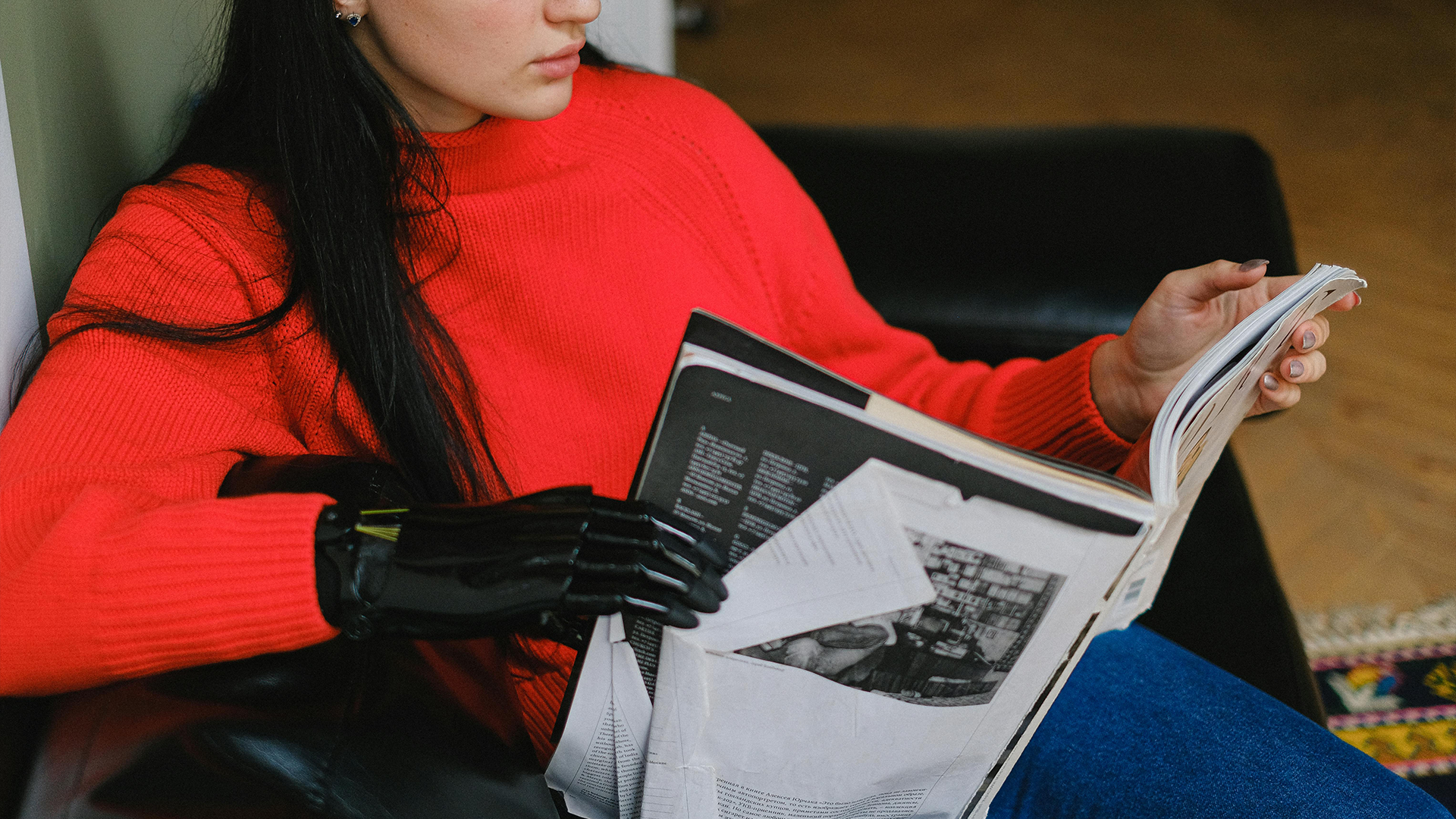 Woman with prosthetic hand reading magazine